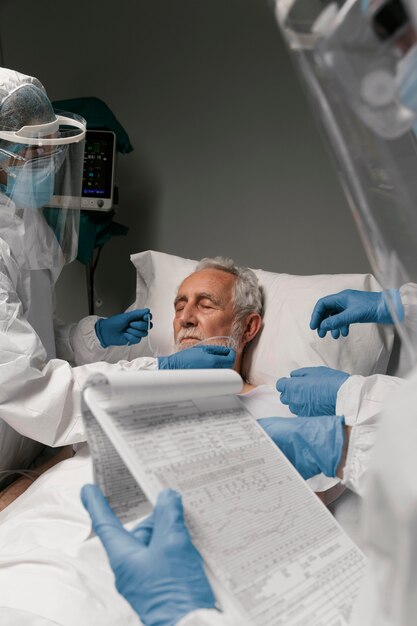 Elderly man with respirator next to doctors