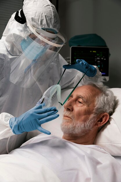 Elderly man with respirator in a hospital bed