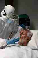 Foto gratuita uomo anziano con respiratore in un letto d'ospedale