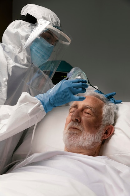 Elderly man with respirator in a hospital bed