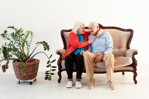 Free photo elderly man and woman sitting on a sofa