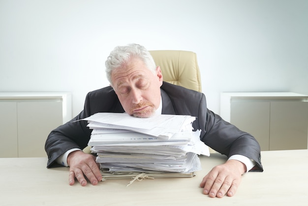 Free photo elderly manager overwhelmed by work