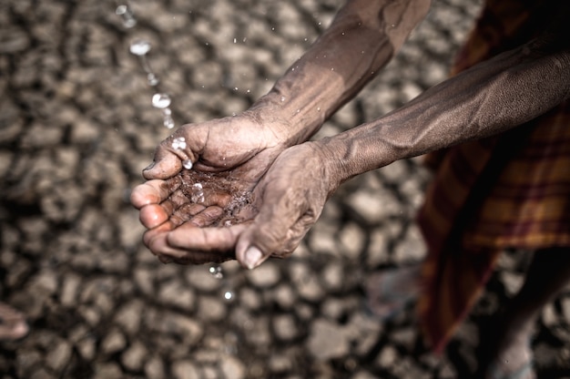 Free photo elderly men are exposed to rainwater in dry weather, global warming