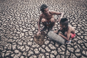 Elderly men and boy find fish on dry ground, global warming