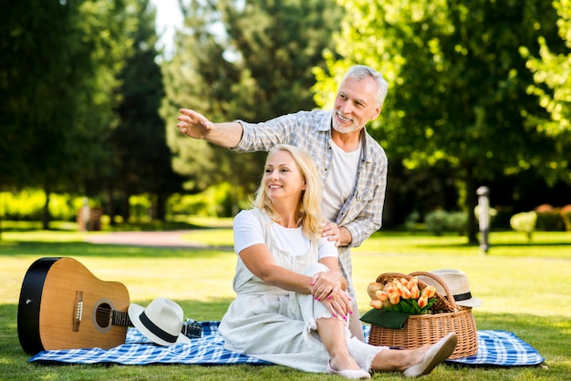 Elderly smiley couple looking away at the park