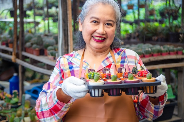 Elderly woman holding pot of cactus with sales price