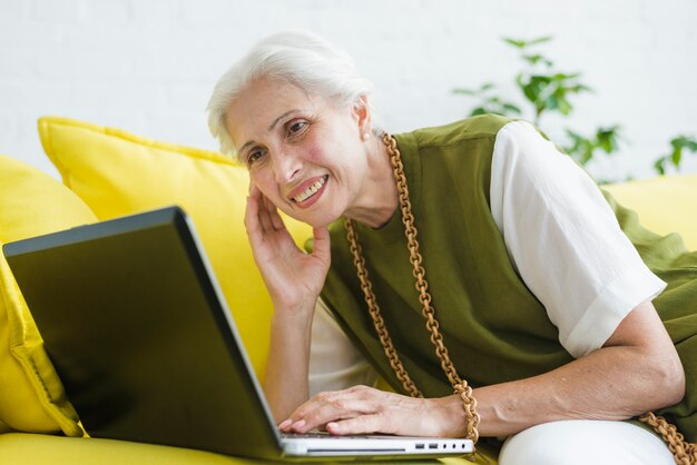 Free photo an elderly woman looking at laptop