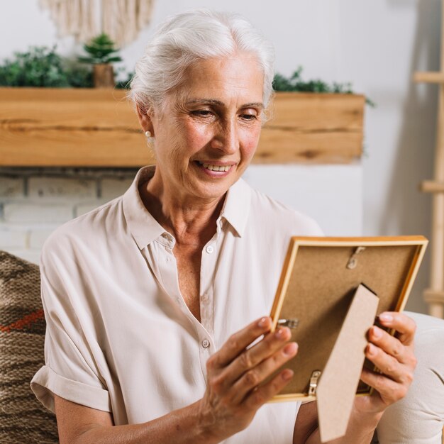 An elderly woman looking at photo frame