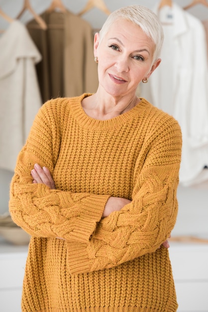 Elderly woman posing with crossed arms and smiling