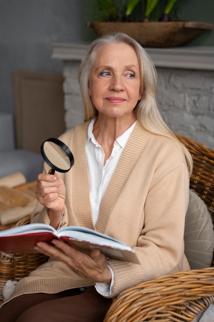 無料写真 虫眼鏡を使いながら読書する年配の女性