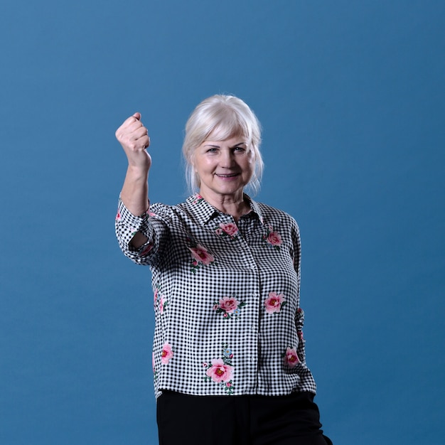 Free photo elderly woman showing fist