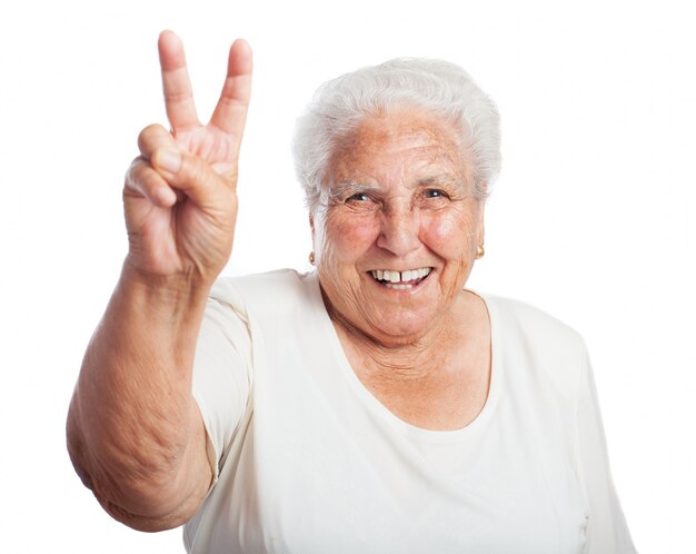 Elderly woman smiling with two raised fingers