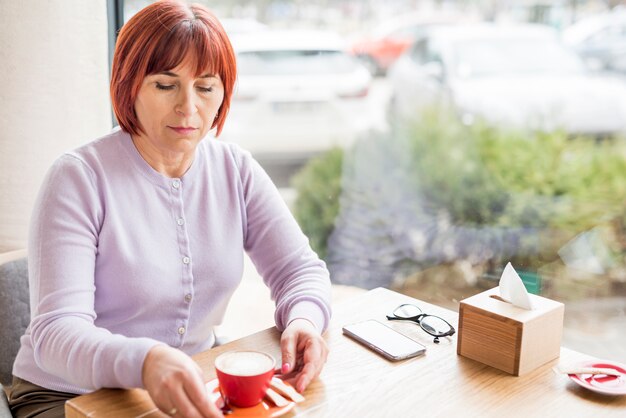 Elderly woman taking coffee