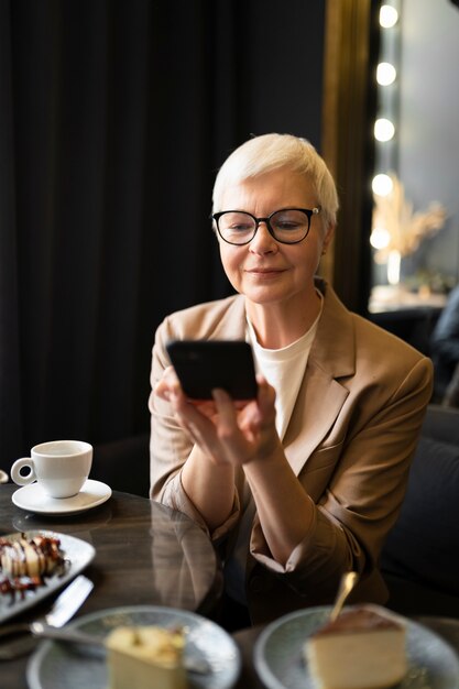 Elderly woman taking a photo of the food on the table during a gathering