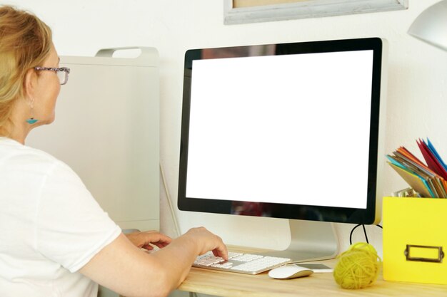빈 화면이 컴퓨터를 사용하는 노인 여성