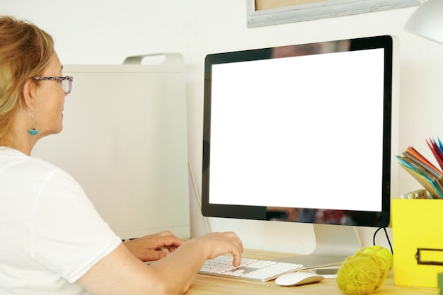 空白の画面のコンピューターを使用して年配の女性