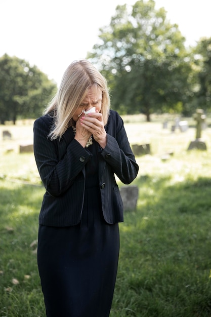 Elderly woman visiting the grave of loved one