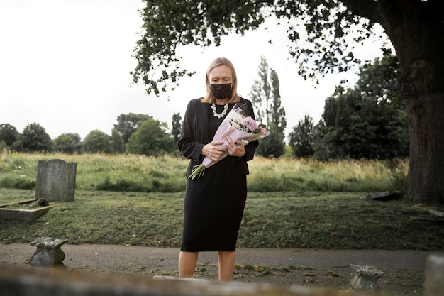 Elderly woman visiting the grave of loved one