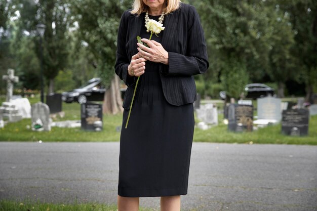 Elderly woman visiting the grave of loved one