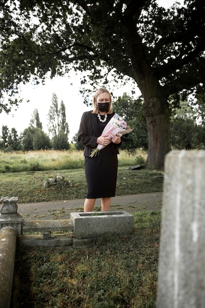 Elderly woman visiting the grave of loved one