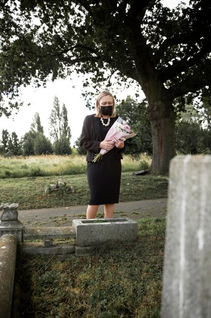 Elderly woman visiting the grave of loved one