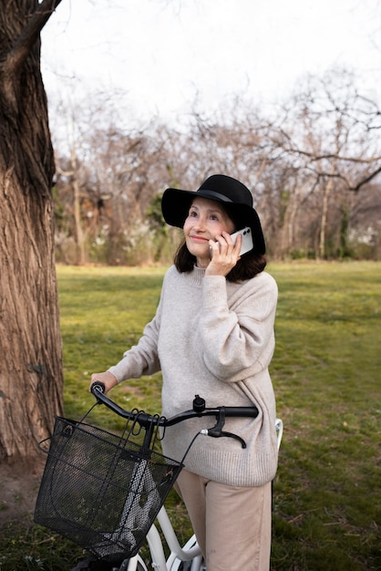 Foto gratuita donna anziana che cammina con la sua bici