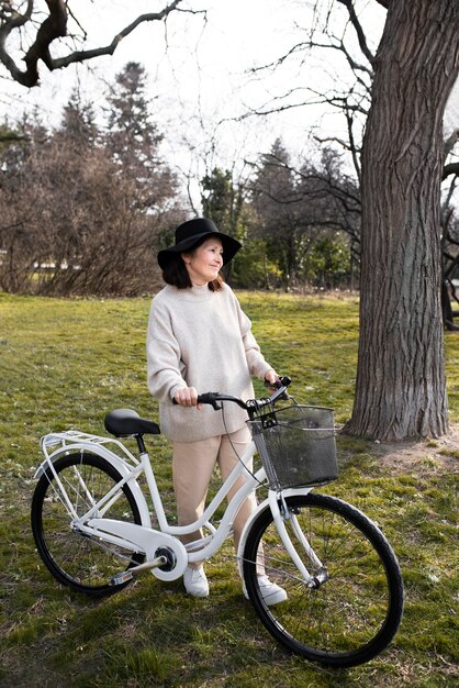 自転車で歩く年配の女性