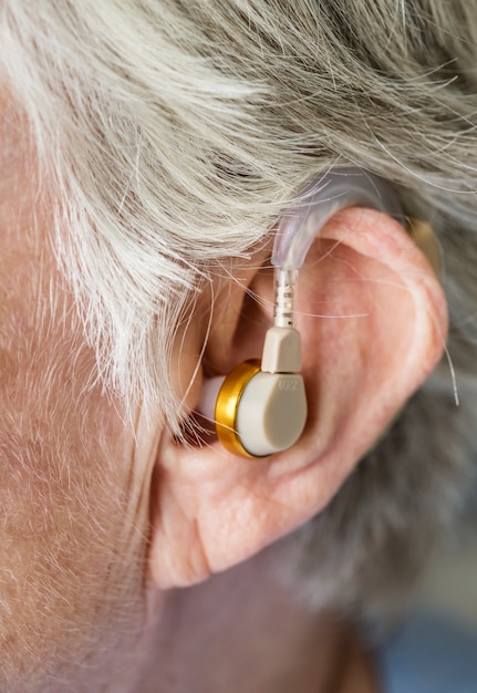 Free photo elderly woman wearing a hearing aid