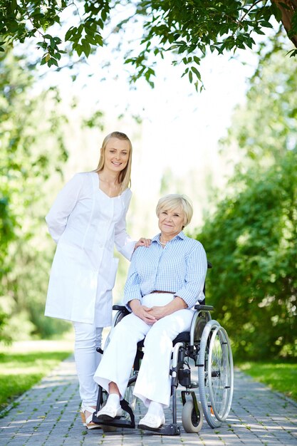 Elderly woman with disability and caregiver