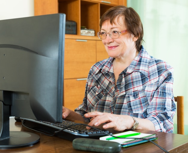 無料写真 コンピュータで働く高齢者の女性