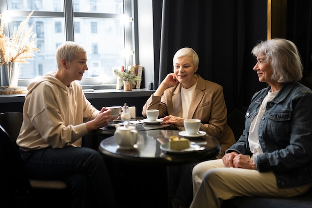 Elderly women drinking coffee and talking during a gathering