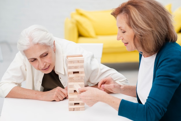 Free photo elderly women playing jenga together