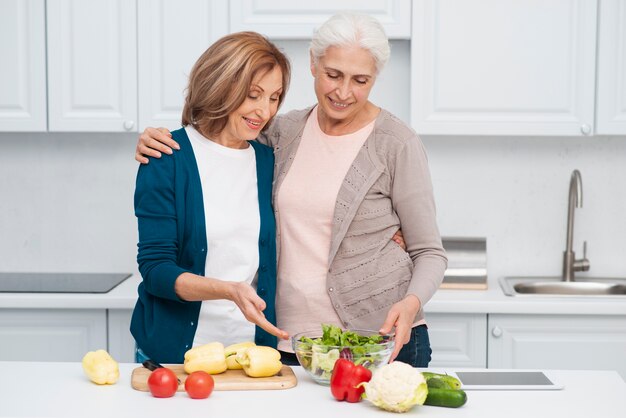 テーブルの上の野菜を持つ高齢者の女性