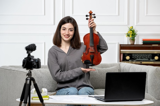 Free photo elearning remotely giving violin classes at home young cute beautiful girl happy