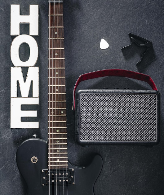 Free photo electric guitar and amplifier on a dark background with decorative word home