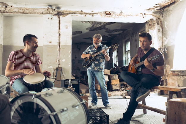 Electric guitar players and drummer behind the drum set.