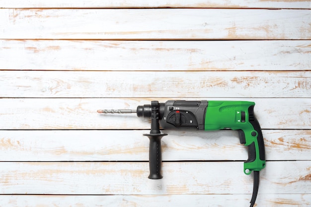 Electric hammer drill lies on a wooden table