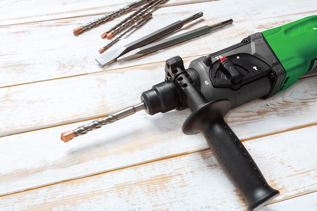 Electric hammer drill lies on a wooden table