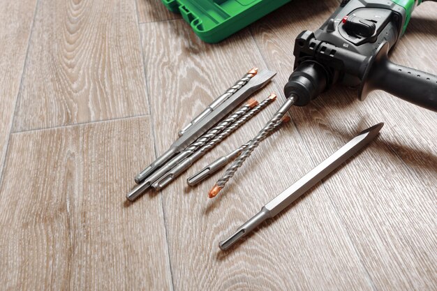 Electric hammer drill lies on a wooden table