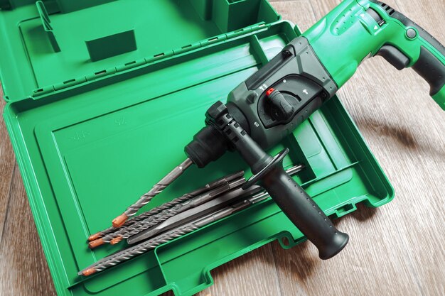 Electric hammer drill lies on a wooden table