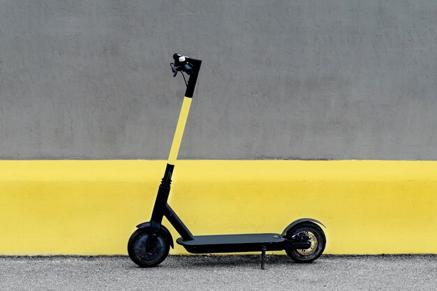 Electric kick scooter against wall. ultimate grey and illuminating.