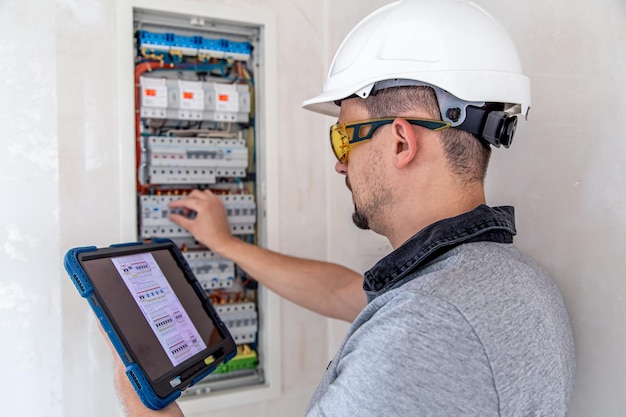 Free photo electrical technician looking focused while working in a switchboard with fuses