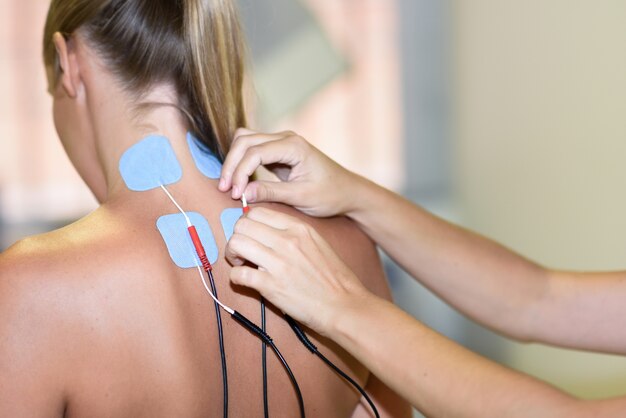 Electro stimulation in physical therapy to a young woman