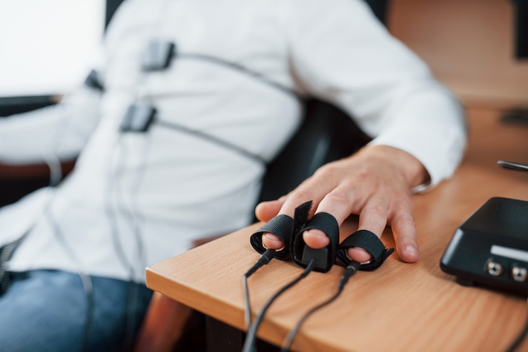 Free Photo electrodes on fingers. suspicious man passes lie detector in the office. asking questions. polygraph test