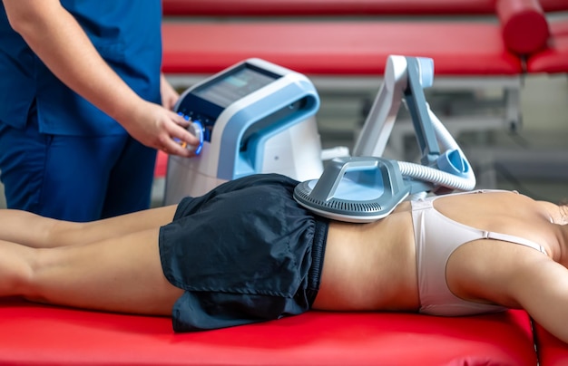 Free photo electromagnetic therapy of the back physiotherapist doctor uses medical equipment