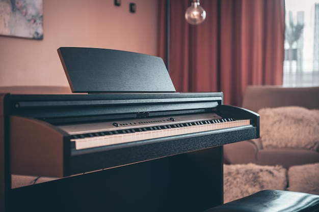 Электронное пианино в интерьере комнаты на размытом фоне