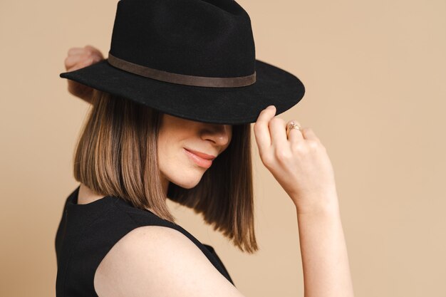 Элегантный портрет молодой стильной женщины в черной шляпе
