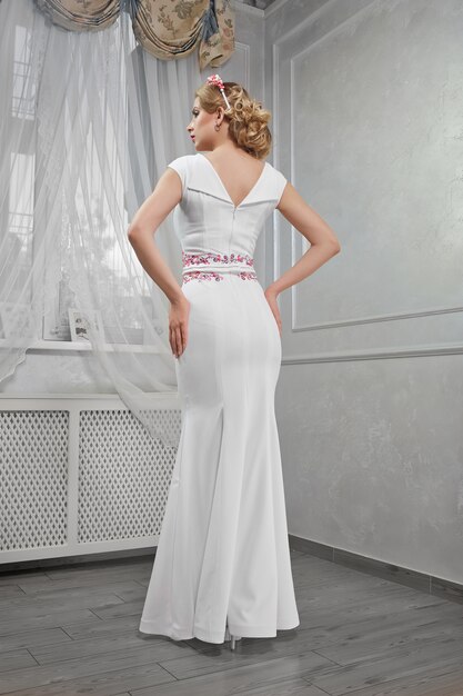 Элегантная, красивая, модная женщина-блондинка в длинном белом платье