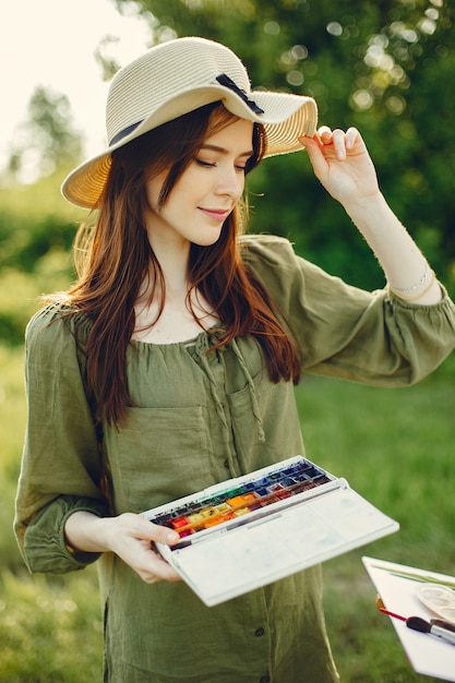 Ragazza elegante e bella pittura in un campo