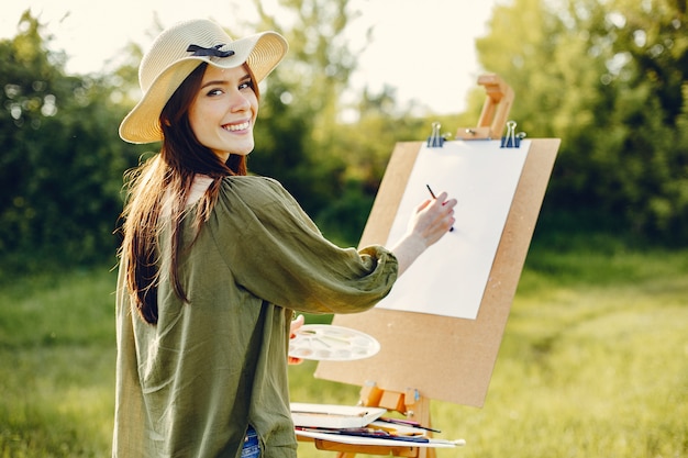 Элегантная и красивая девушка рисует в поле